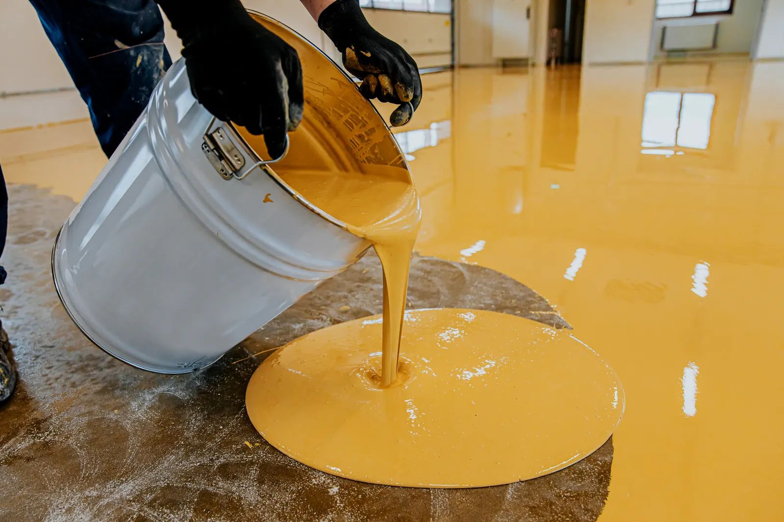 Epoxy resin being poured onto a prepared concrete floor